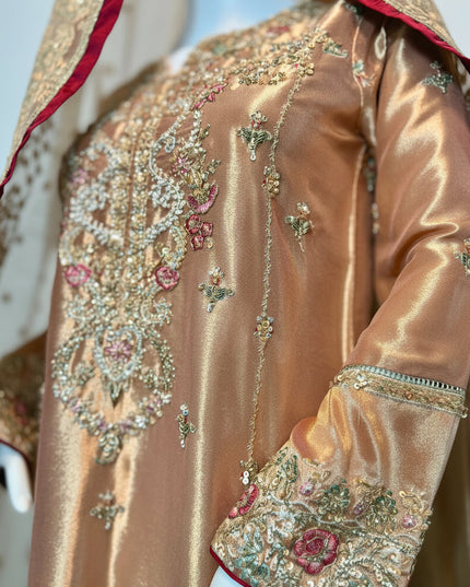 Close-up of a traditional embroidered garment with intricate designs on a plain background