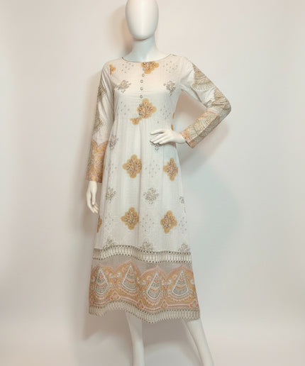 White dress with floral patterns on a mannequin against a plain background