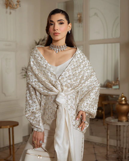 Woman in a sparkling silver outfit standing in an elegant room.