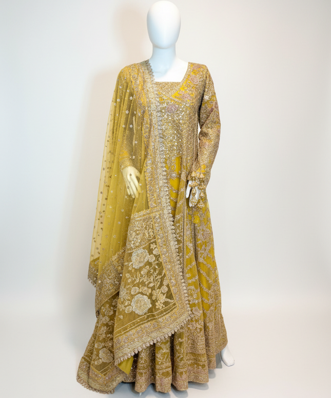 Yellow embroidered traditional outfit on a mannequin against a white background