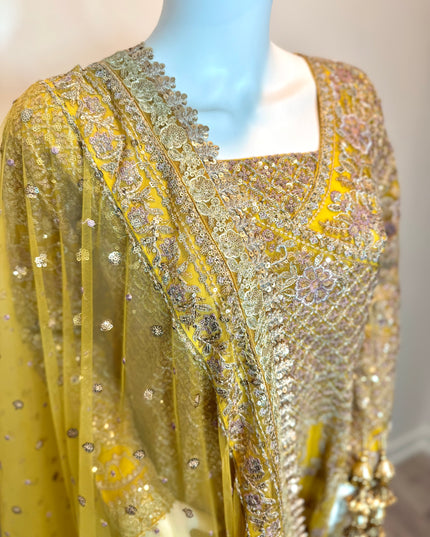 Mannequin wearing a yellow embroidered outfit with intricate patterns