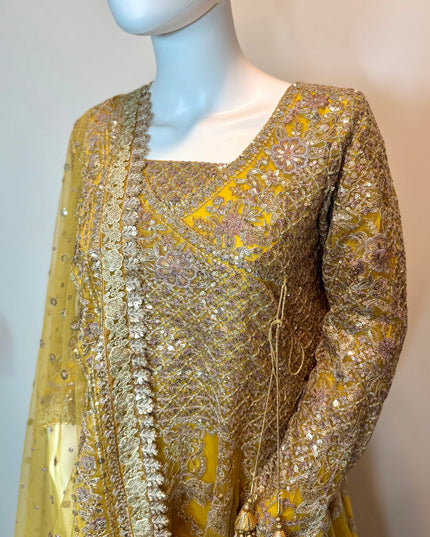 Gold embroidered traditional outfit on a mannequin against a neutral background