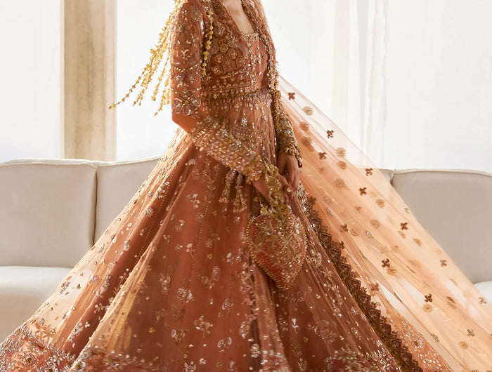 Woman in a traditional embroidered outfit standing indoors with a neutral background