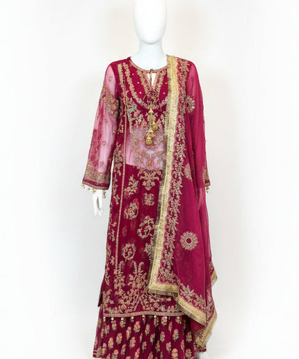 Maroon embroidered traditional outfit on a mannequin against a white wall.