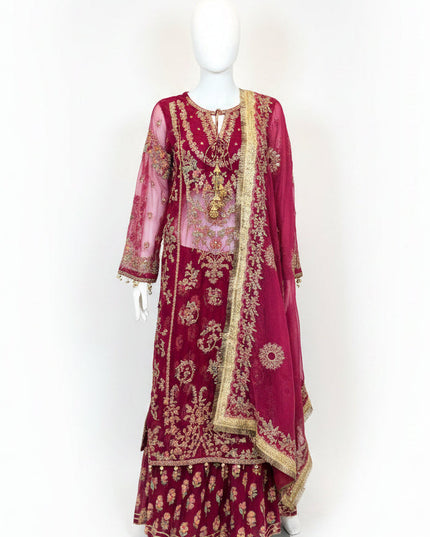 Maroon embroidered traditional outfit on a mannequin against a white wall.