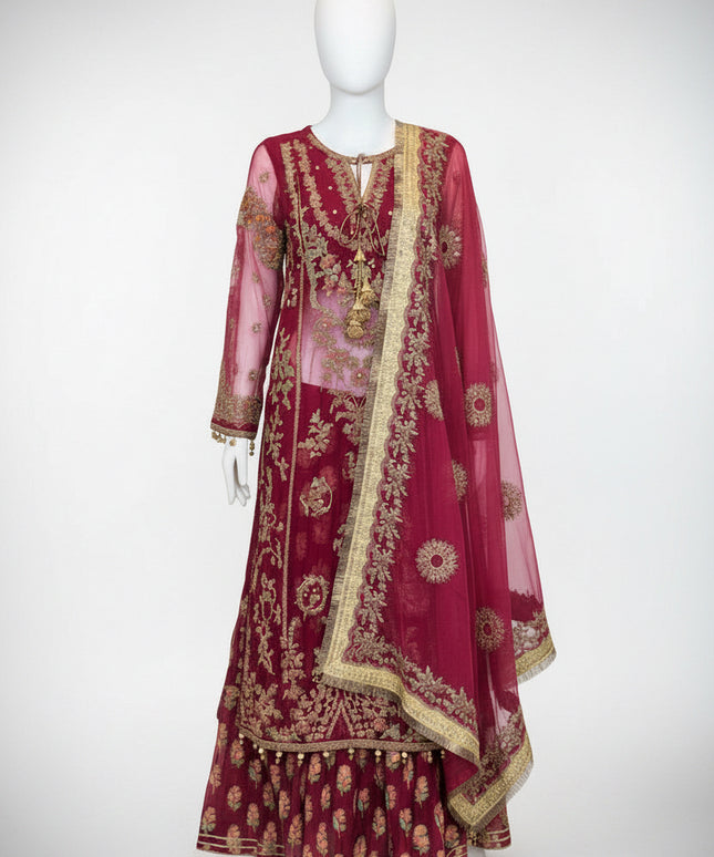 Maroon embroidered traditional outfit on a mannequin against a white wall.