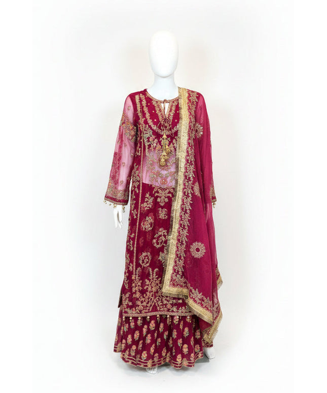 Maroon embroidered traditional outfit on a mannequin against a white wall.