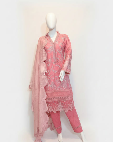 Mannequin wearing a pink embroidered outfit with a matching dupatta on a wooden floor.