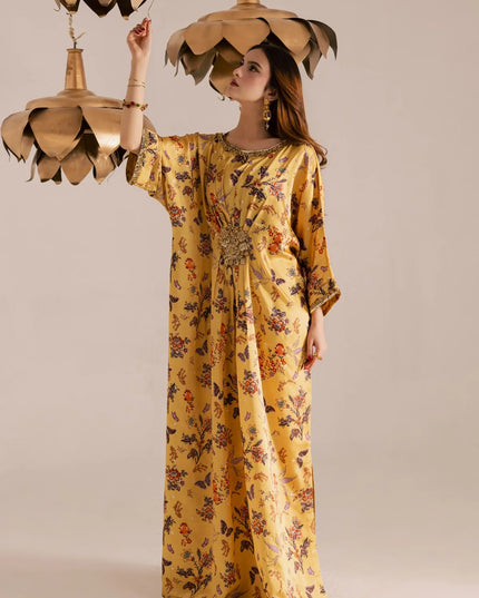 Woman in a yellow floral dress holding gold lotus-shaped lamps against a beige background